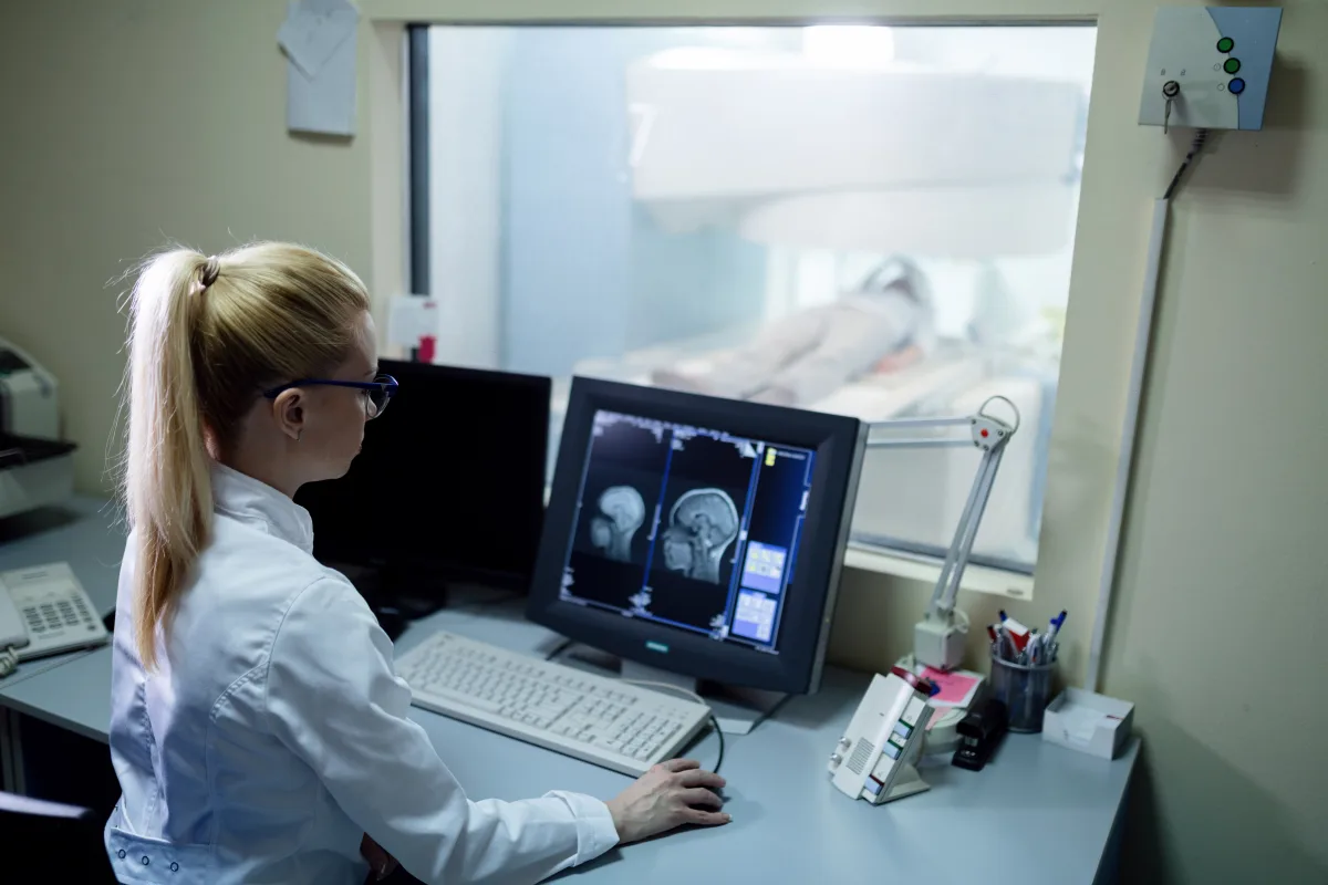 רדיולוג בוחן תוצאות MRI על מסך בחדר הבקרה